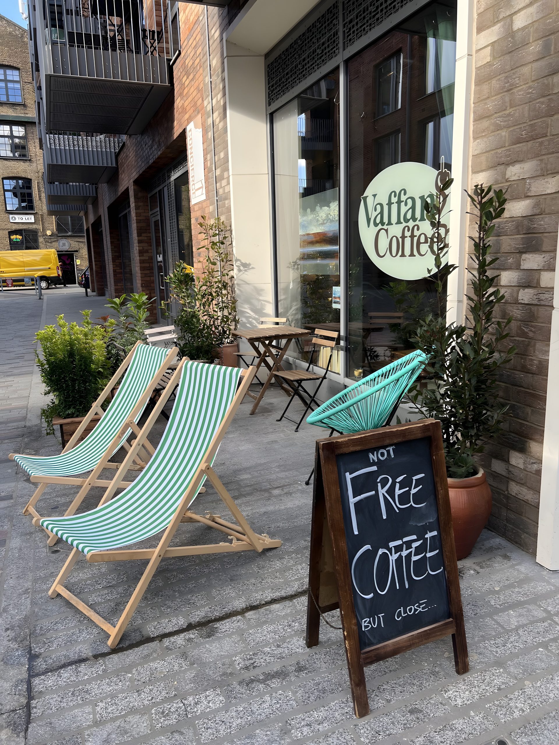 Vaffancoffee shopfront on Wallis Road with green striped deckchairs and an A-board reading not free coffee but close